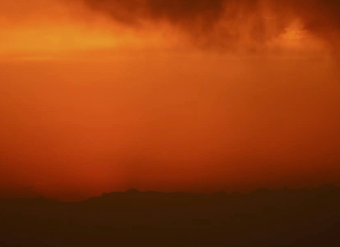 Dramatic orange-red sky landscape with silhouetted hills - sunset landscape photography