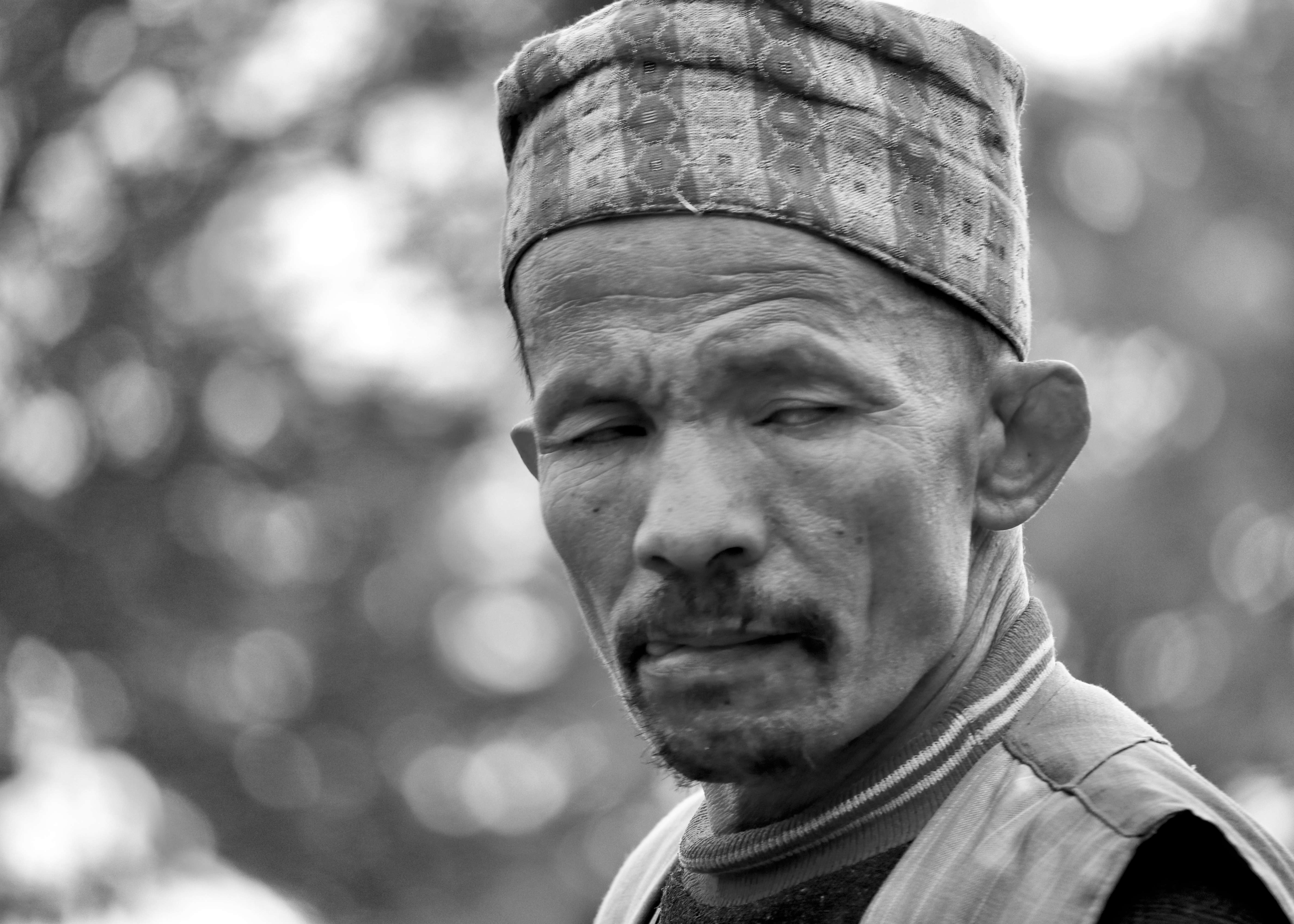 Black and white portrait of elderly man with knit cap showing weathered features - character portrait photography
