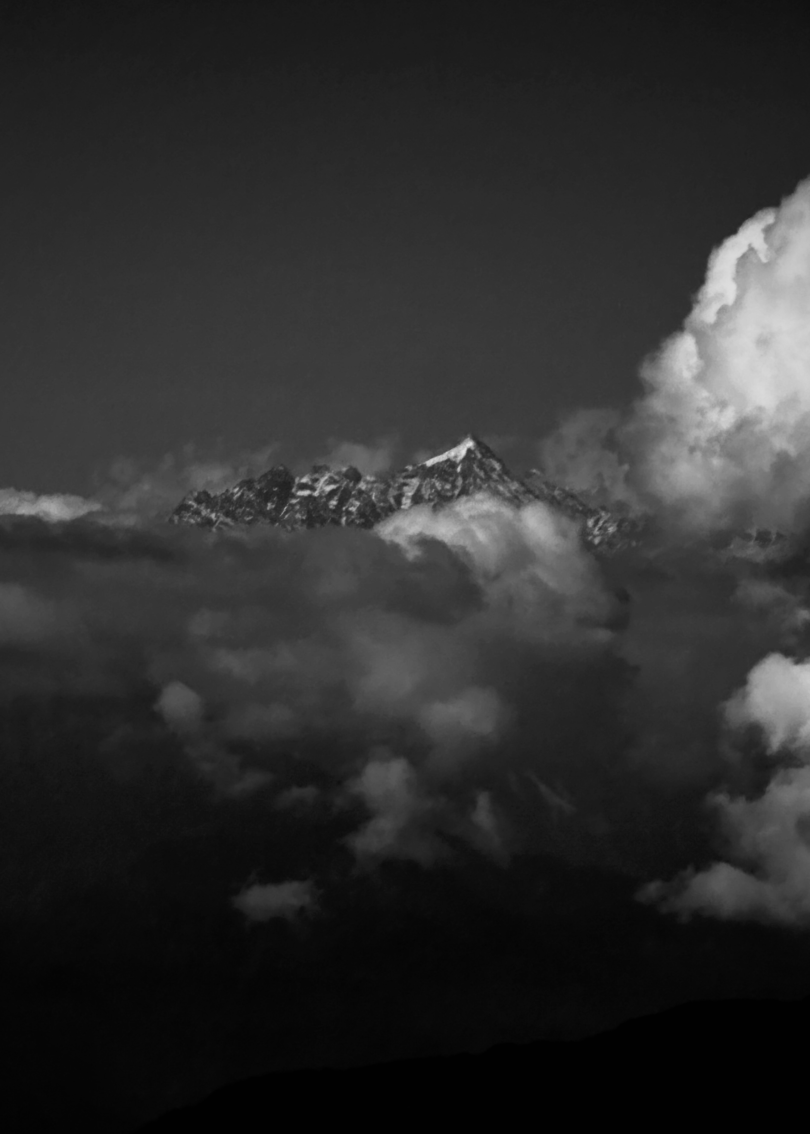 Majestic snow-capped mountain peaks emerging from clouds - mountain landscape photography