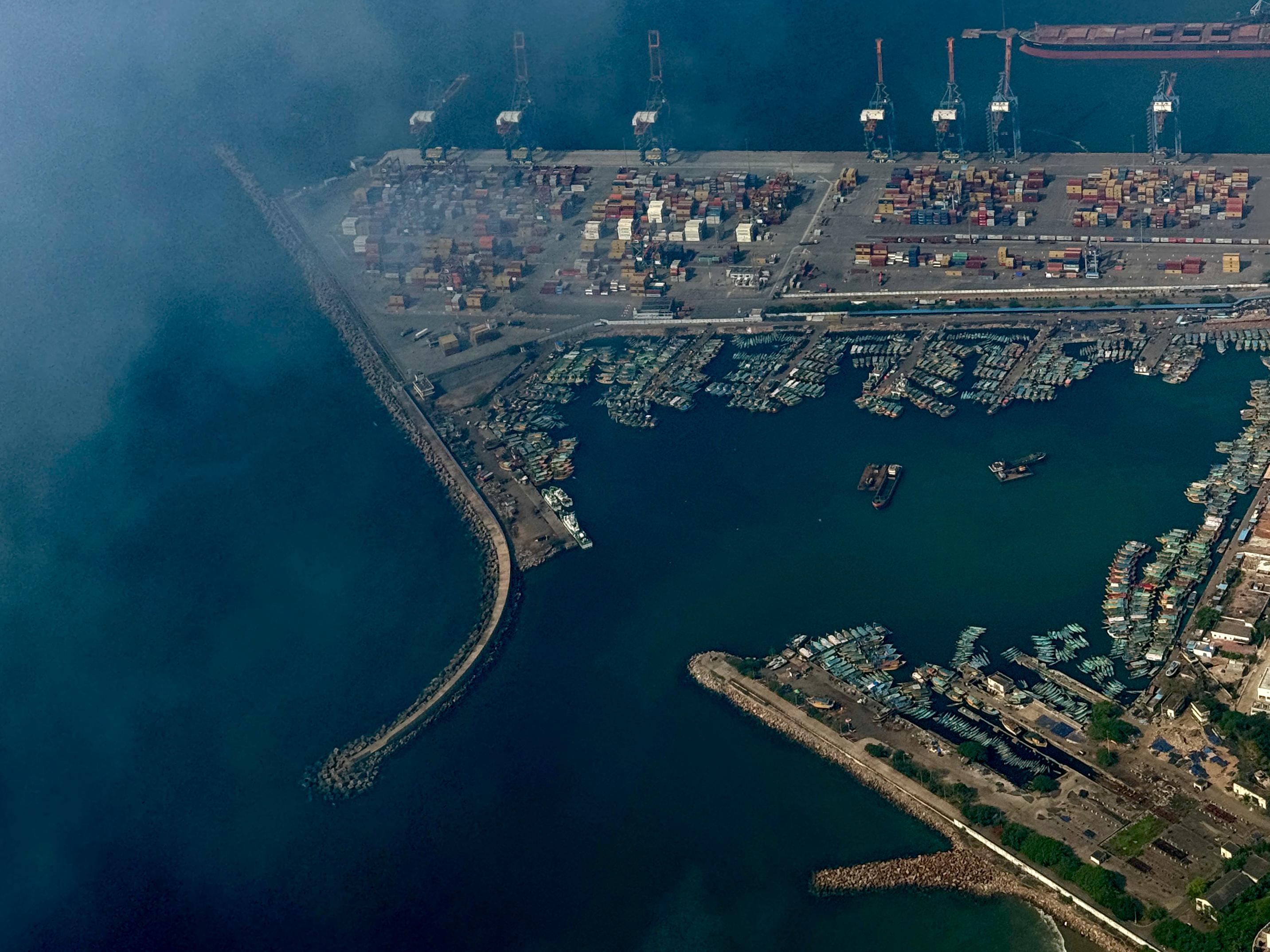 Aerial view of industrial harbor with shipping containers, cranes, and marina - coastal infrastructure photography from above