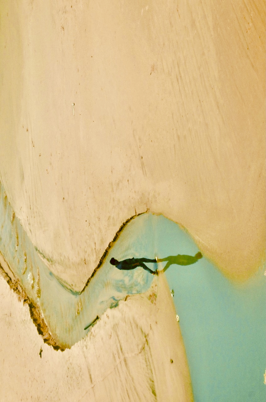 Abstract underwater swimmer silhouette in golden cream tones with ethereal lighting - artistic water photography